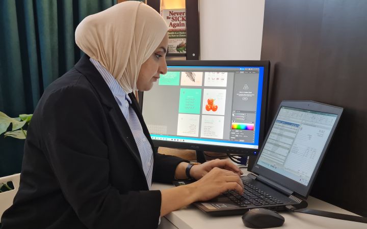 Shumoos Ghanim Jaber typing on her laptop