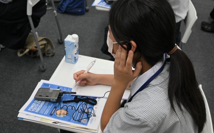 High school student listening to the simultaneous interpretation of the event