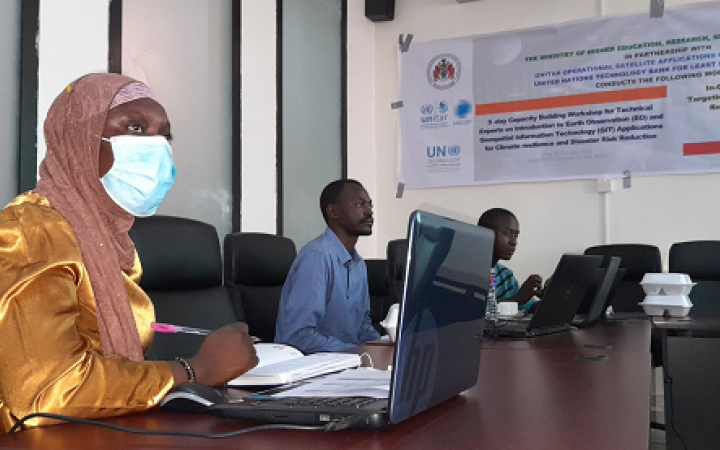 Female participant seated in front of a laptop wearing a face mask 