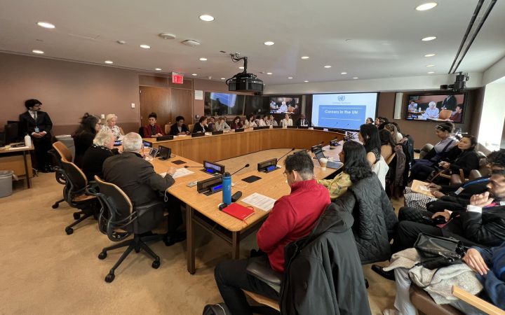 A full room of participants listening to Ms Holly White speak about the UN