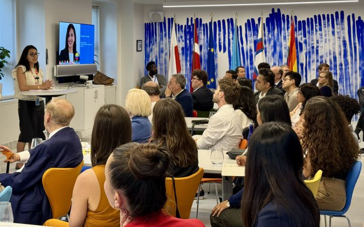 Photo of the venue filled with audience and speakers