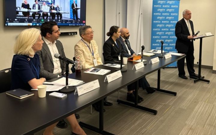 Panelists sitting down on a table for the programme