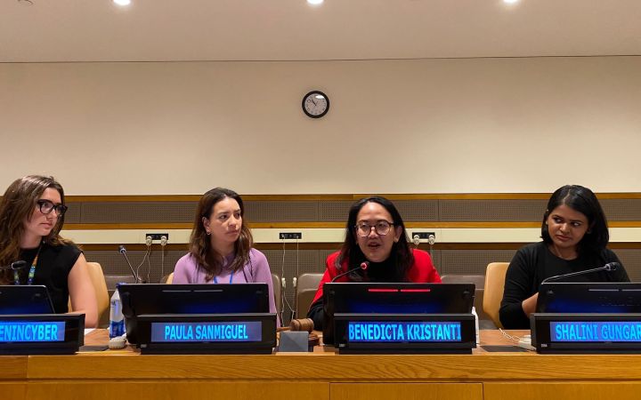 Women speakers sitting down speaking in front of the mic