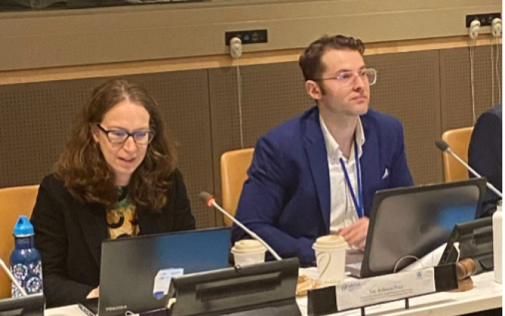 Two people sitting in front of microphones and screens