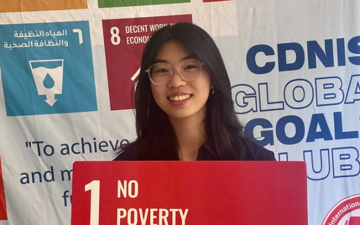 Agnes Chiu holding an SDG 1 board