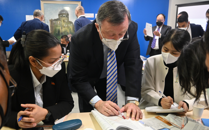People are standing in front of a desk, actively engaged in a group activity.