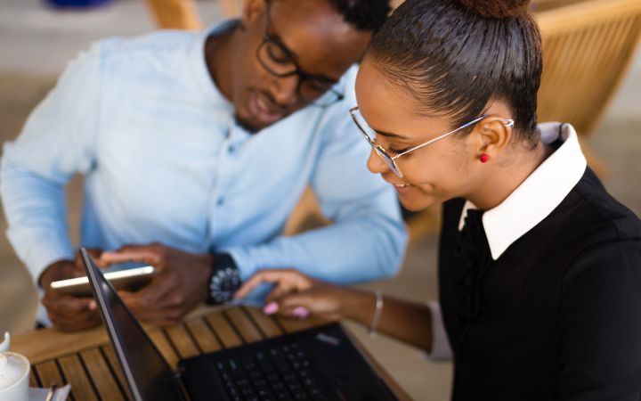 African man and woman looking at a laptop