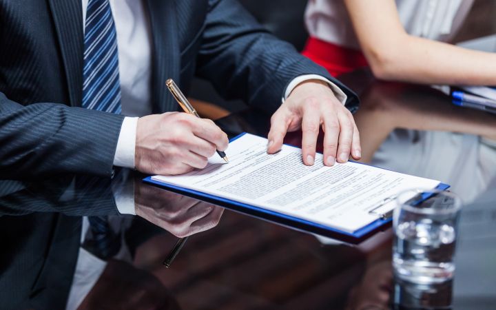 Hands of business people signing a contract