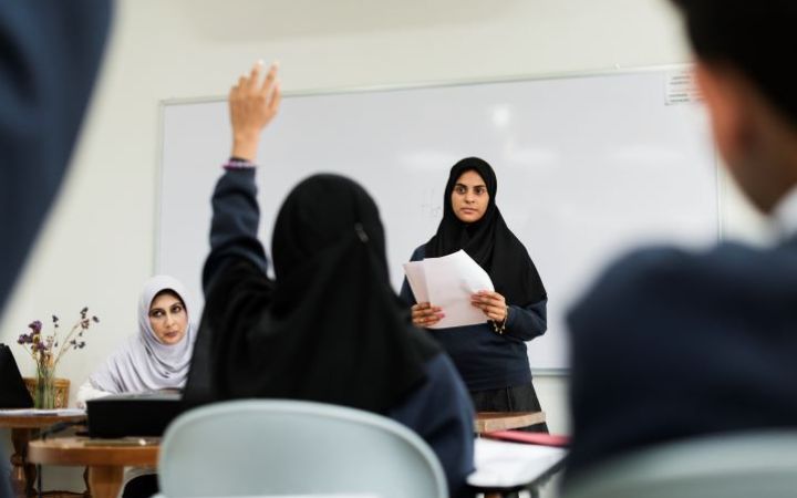 Student raising her hand to be called by her teachers