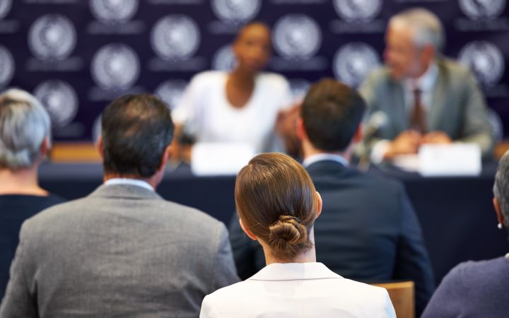 Conference guests listening to the panelists on stage