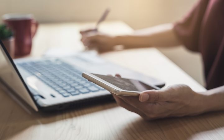 Young woman using a smartphone and a laptop